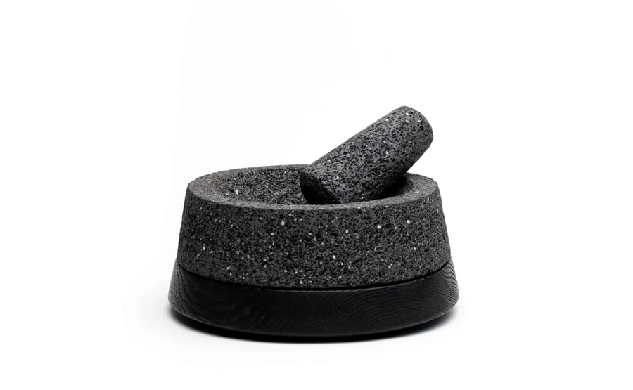 Molcajete in use on a rustic kitchen counter