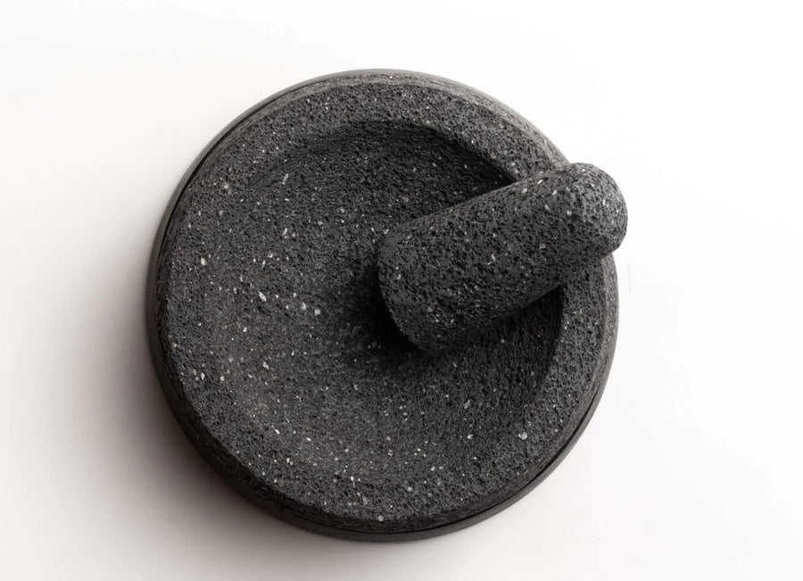 Whole spices ready to grind in a lava stone molcajete